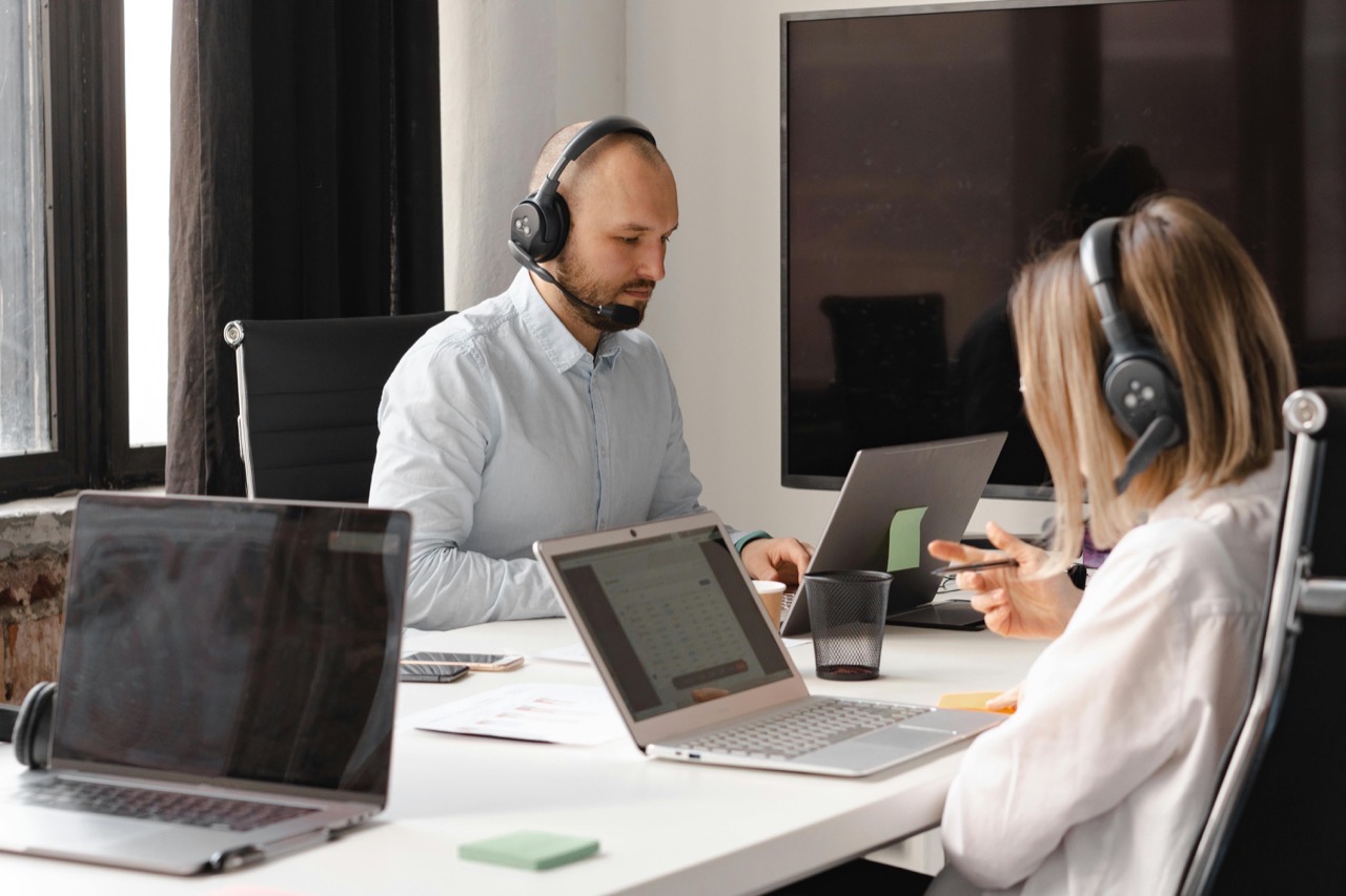 Deux gestionnaires de paie MaPaye, casque sur les oreilles, au téléphone avec des clients